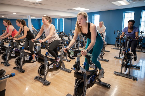 A group of students take part in a spinning class.