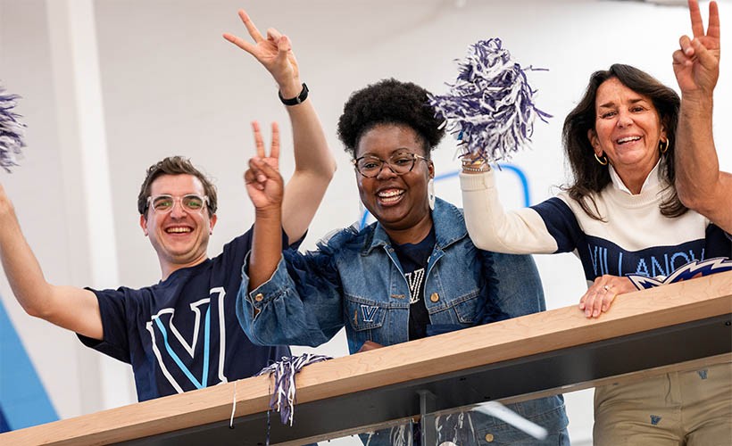 Three Villanova fans cheering in VU gear