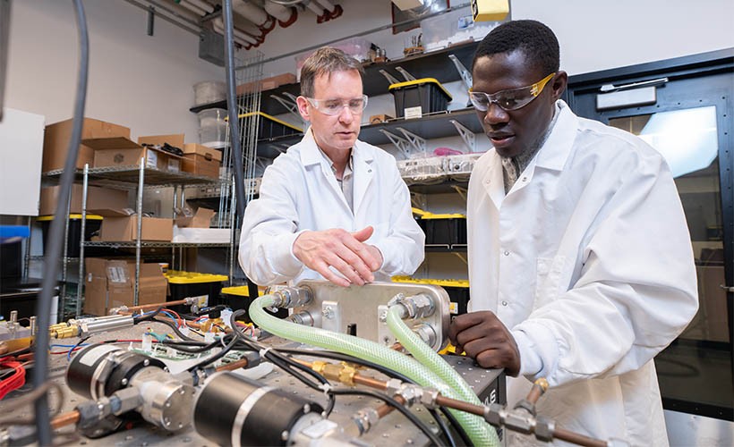 Aaron Wemhoff, PhD, and a graduate student in a Mechanical Engineering lab
