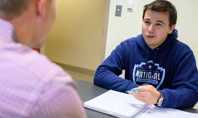 student speaking with a faculty member