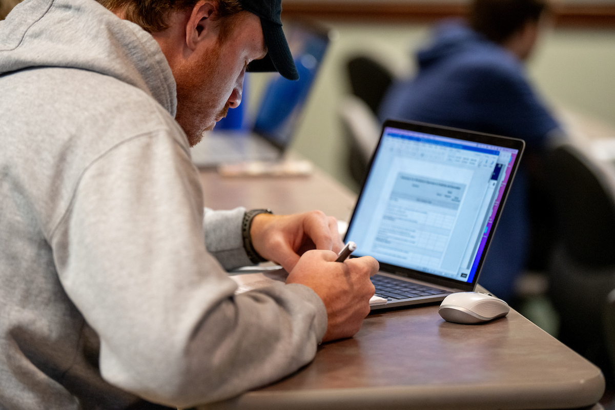 photo of student working on a laptop in the classrom