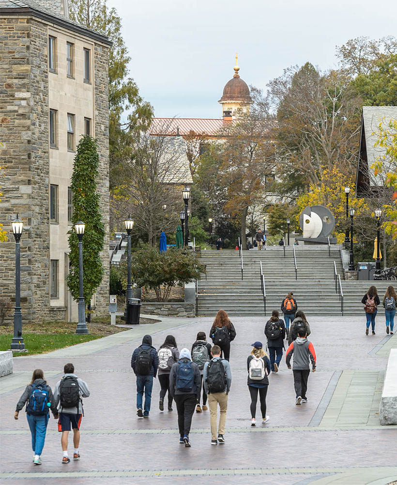 A group of Villanova students with backpacks walking on campus. 
